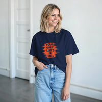 Load image into Gallery viewer, Woman wearing a navy blue t-shirt with motivational text in a bright room.
