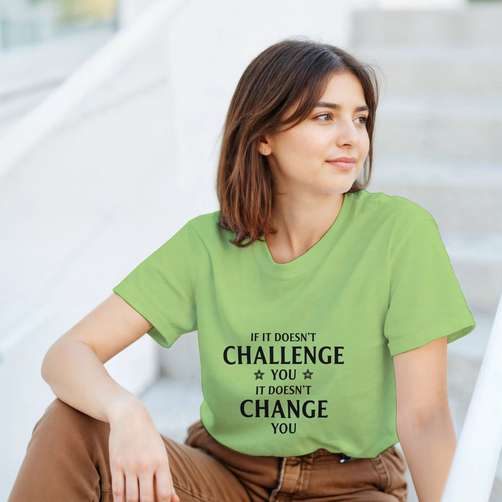 Woman wearing a green t-shirt with a motivational quote, sitting outdoors.