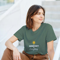 Load image into Gallery viewer, Woman wearing a green t-shirt with &#39;MINDSET is Everything&#39; text and light bulb graphic.
