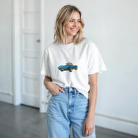 Load image into Gallery viewer, Woman wearing a white t-shirt with a blue car graphic and light blue jeans indoors.
