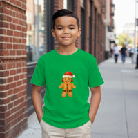 Load image into Gallery viewer, Child wearing a green t-shirt with a gingerbread man graphic on a city street.
