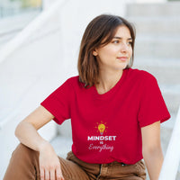 Load image into Gallery viewer, Woman wearing a red t-shirt with &#39;MINDSET is Everything&#39; text sitting on steps.
