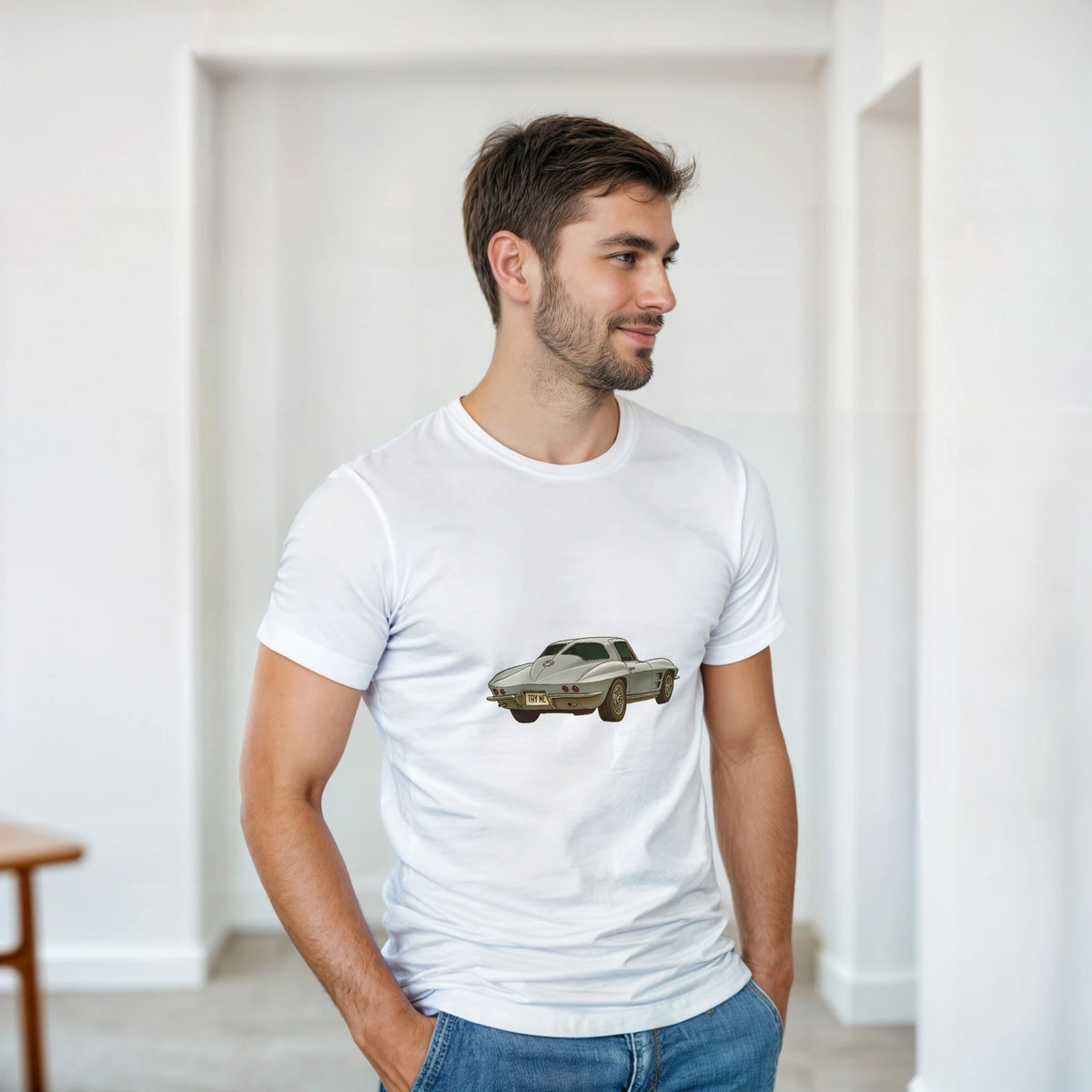 Man wearing a white t-shirt with a car graphic in a minimalistic room.