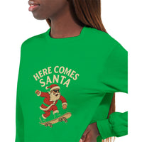 Load image into Gallery viewer, Green sweatshirt with &#39;Here Comes Santa&#39; graphic featuring a skater Santa Claus.
