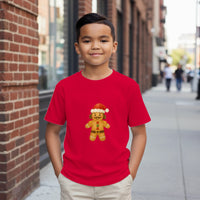 Load image into Gallery viewer, Child wearing a red t-shirt with a gingerbread man design on a city street.
