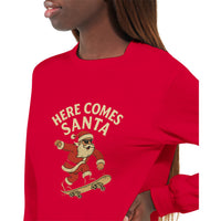 Load image into Gallery viewer, Red t-shirt with &#39;Here Comes Santa&#39; graphic featuring a skater Santa Claus on a white background.
