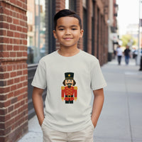 Load image into Gallery viewer, Child wearing a white t-shirt with a nutcracker design on a city street.
