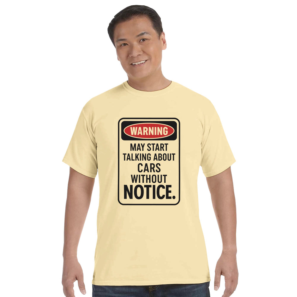 Man wearing a light yellow t-shirt with a humorous car-themed warning design.