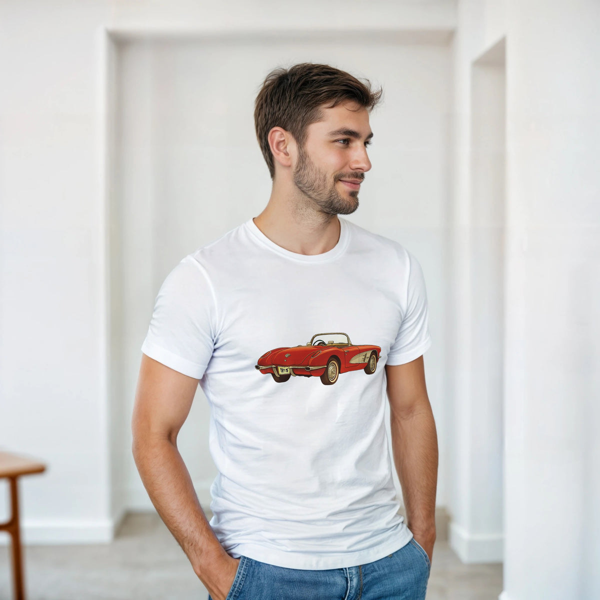 Man wearing a white t-shirt with a red car graphic in a minimalistic room.