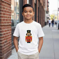 Load image into Gallery viewer, Child wearing a white t-shirt with a nutcracker design on a city street.
