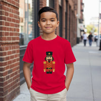 Load image into Gallery viewer, Child wearing a red t-shirt with a nutcracker design on a city street.
