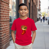 Load image into Gallery viewer, Child wearing a red t-shirt with a Christmas stocking design on a city street.
