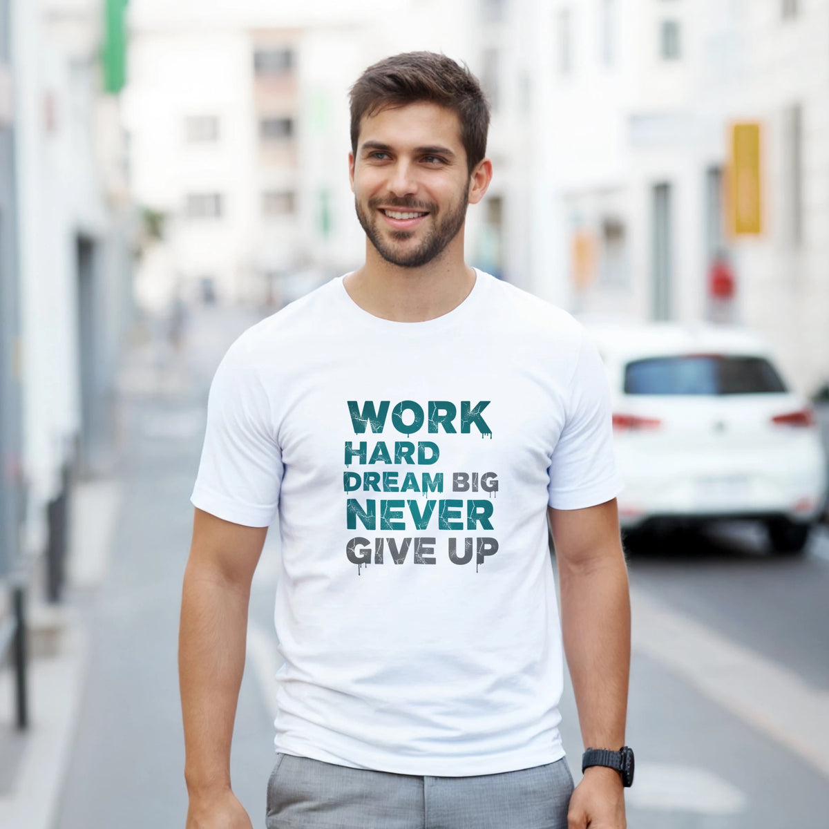 Man wearing a white t-shirt with motivational text on a city street