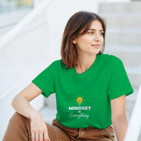 Load image into Gallery viewer, Woman wearing a green t-shirt with &#39;MINDSET is Everything&#39; text and graphic.
