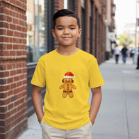 Load image into Gallery viewer, Child wearing a yellow t-shirt with a gingerbread man design on a city street.
