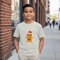 Load image into Gallery viewer, Child wearing a white t-shirt with a gingerbread man graphic on a city street.
