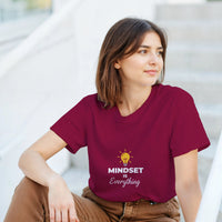 Load image into Gallery viewer, Woman wearing a maroon t-shirt with &#39;MINDSET is Everything&#39; text and light bulb graphic.
