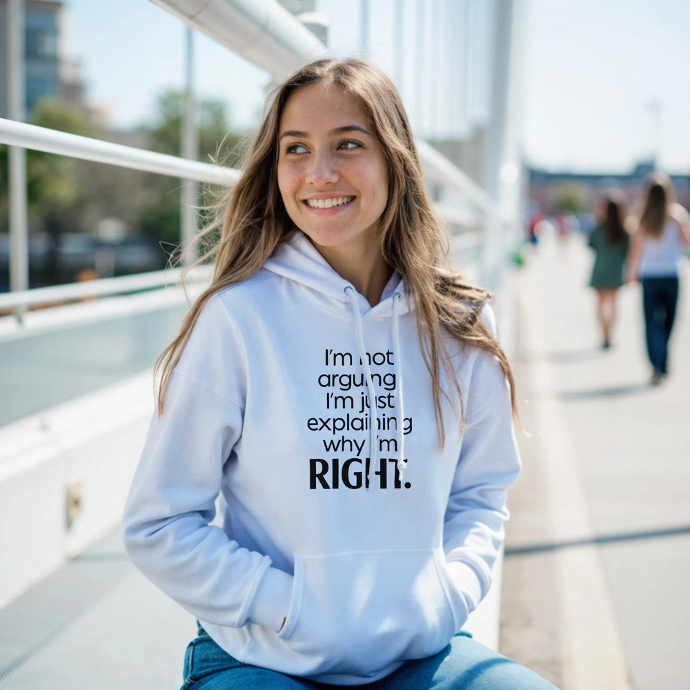 Woman wearing a light blue hoodie with text, sitting outdoors on a sunny day.